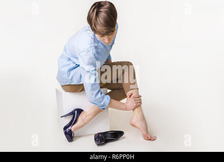 Jeune femme en hauts talons en massant son jambes fatiguées Banque D'Images