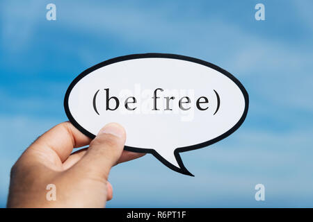 Libre d'un jeune homme de race blanche montrant une pancarte, en forme de bulle de dialogue, avec le texte libre écrit en C, contre le ciel bleu Banque D'Images
