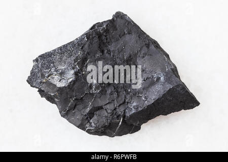 Shungite en pierre de schiste rugueux sur blanc Banque D'Images