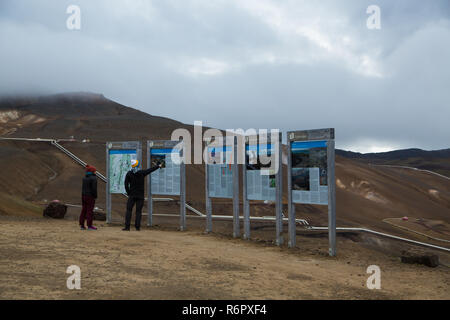 Les touristes à la recherche de conseils d'informations touristiques avec des informations à Hverir, Namafjall, Islande Banque D'Images