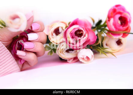 Nail design manucure décoré de fleurs. Mains de femme avec rose et blanc sur les ongles manucurés holding belles roses Banque D'Images