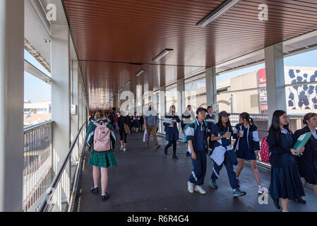 Les enfants de l'école utiliser la passerelle pour piétons tous temps qui joint Hornsby gare et quartier commerçant, en toute sécurité en évitant St George occupé ci-dessous. Banque D'Images