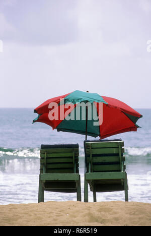 Chaises avec parasol à Baga beach, Goa, Inde Banque D'Images