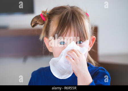 Little girl blowing son nez dans un mouchoir. Banque D'Images