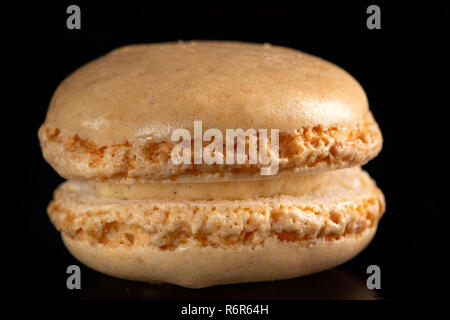 Seul brown sweet macaron sur fond noir Banque D'Images