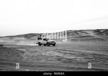 Hurghada, Egypte - 26 Février 2017 : Véhicule tout-terrain de la conduite dans les dunes de désert sur fond de ciel blanc. Safari et l'aventure. Locations et activités extrêmes. Voyage, voyage. Wanderlust Banque D'Images