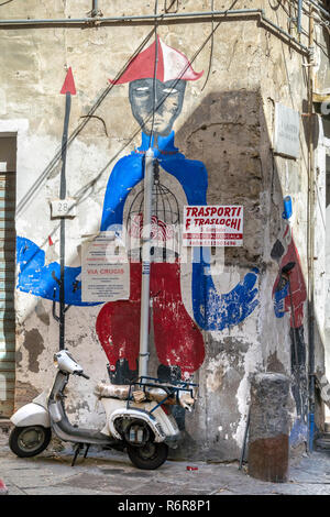 Un vieux scooter garé sur un mur frescoe de Pulcinella, une figure populaire dans la Commedia dell'art et le théâtre de rue depuis le 17ème cen. dans le Quarti Banque D'Images