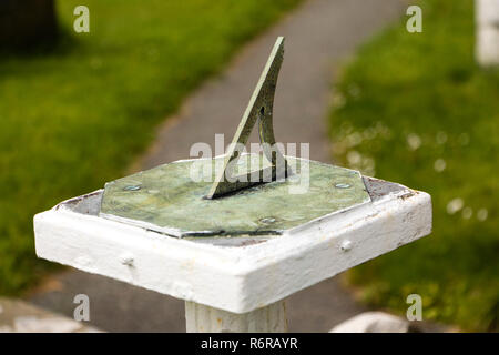 Cadran solaire horizontal en cuivre avec bord incliné sur socle en jardin Banque D'Images