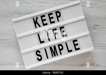 "Simplifier la vie" mots sur carte moderne en bois blanc table, vue de dessus. Mise à plat, d'en haut. Banque D'Images