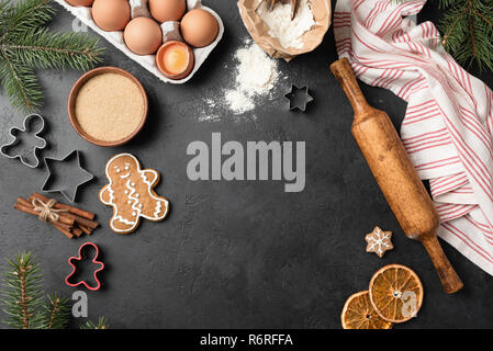 Contexte La cuisson des biscuits. Gingerbread cookies télévision jeter sur fond de béton noir. Vue de dessus, l'espace de copie de texte, de la fiche ou le message d'accueil Banque D'Images