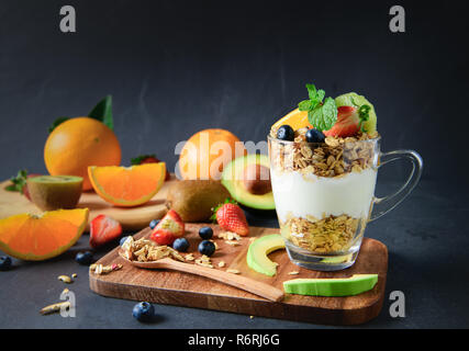 Granola, yogourt et fruits sur la garniture en verre sur la table en bois, des aliments sains pour le régime alimentaire concept Banque D'Images