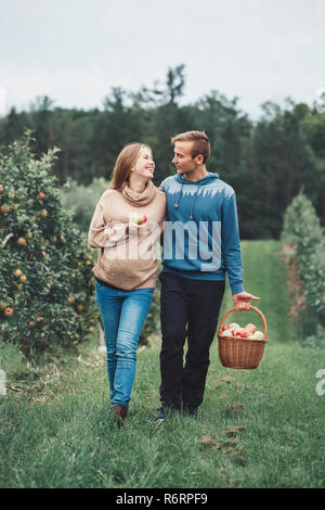En toute sécurité avec une assurance santé durant la grossesse et la parentalité. Portrait de jeune femme enceinte libre avec mari sur apple farm. Belle mère prévoyante et fu Banque D'Images