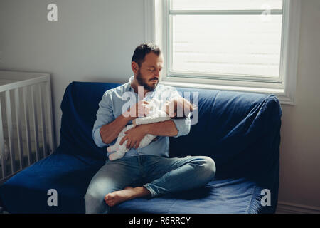 Portrait de race blanche d'âge moyen d'alimentation père fils fille nouveau-né avec du lait. Parent mâle homme tenant un enfant sur ses mains. De vie authentique c Banque D'Images