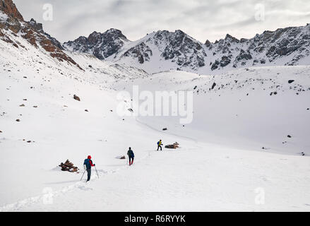 Trois touristes sur le sentier de neige grimper les montagnes Banque D'Images