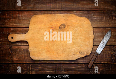 Une planche à découper en bois avec un couteau rural vintage. L'arrière-plan. Banque D'Images