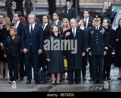 L'ancien président George W. Bush et épouse de Laur (centre), Jeb Bush et sa femme Paloma (à gauche) et d'autres membres de la famille au garde à vous comme une garde d'honneur militaire porte le cercueil de Bush père, l'ancien président George H. W. Bush, d'un corbillard avant l'enterrement à la proximité de la bibliothèque George Bush Banque D'Images