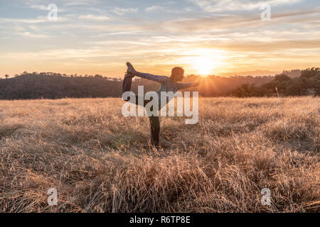 À la fin d'un 19 km randonnée pour Rockhouse Ridge, ce professeur de yoga a effectué la posture du danseur king, coucher de soleil, Henry Coe State Park, Californie Banque D'Images