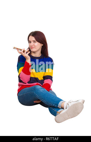 Triste et ennuyé hipster girl holding smartphone pendant les loisirs assis sur le plancher isolé sur fond blanc. Les femmes découragés blogger ennuyer Banque D'Images