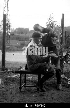 1940 soldats de l'armée allemande WW2 obtenir un style 'Hitler' couper les cheveux dans le nord de la France Banque D'Images