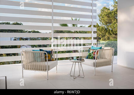 Paire de fauteuils en métal et corde sur terrasse avec moustiquaire dans le neuf villa, Quinta do Lago Banque D'Images