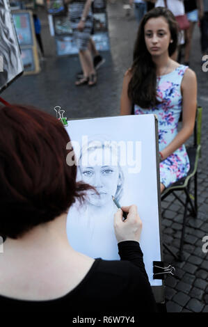 Le dessin de l'artiste femme portrait d'une jeune femme brune, à la Piazza Navona, une place populaire parmi les artistes de rue, les vendeurs et les artistes interprètes ou exécutants, Rome Banque D'Images