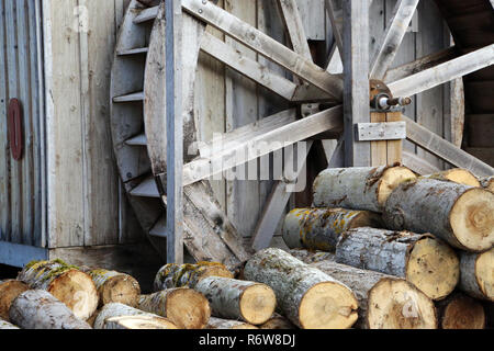 Une immense roue à eau et en bois de sciage coupe à côté d'une cabine Banque D'Images