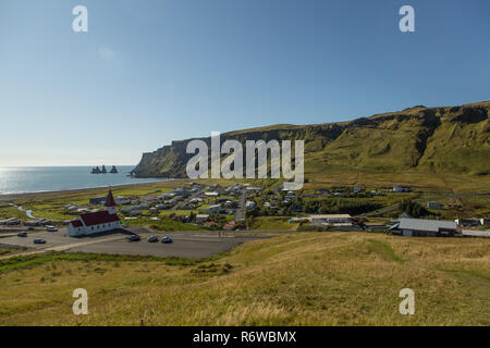 La ville islandaise de Vik dans le sud de l'Islande sur une journée ensoleillée face à la mer avec les colonnes de roche de Reynisdrangar Banque D'Images