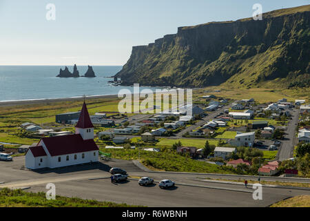 La ville islandaise de Vik dans le sud de l'Islande sur une journée ensoleillée face à la mer avec les colonnes de roche de Reynisdrangar Banque D'Images