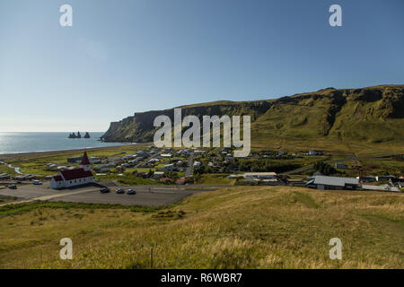 La ville islandaise de Vik dans le sud de l'Islande sur une journée ensoleillée face à la mer avec les colonnes de roche de Reynisdrangar Banque D'Images