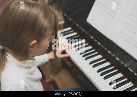 Petite fille d'apprendre à jouer du piano. Banque D'Images