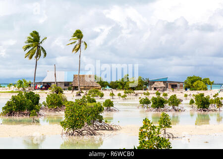 Village sur l'atoll de Tarawa Sud, Kiribati, Micronésie, l'Océanie. Maisons à toit de chaume. La vie rurale sur une plage de Paradise Island à distance sous les palmiers. Banque D'Images