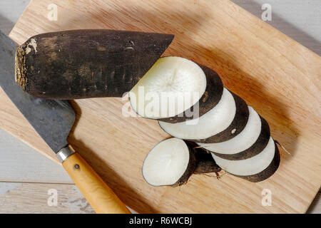 Couper le radis noir en slice sur planche de bois Banque D'Images