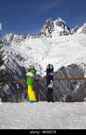 Jeune surfeur prend des photos près de snowboard en hiver vue sur montagne à une journée de soleil. Montagnes du Caucase. Hatsvali Svaneti, région de Géorgie, M Banque D'Images