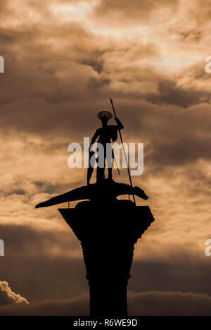 Saint Theodore statue médiévale en bronze avec la lance et le piétinement du bouclier dragon maléfique entre les nuages, au sommet d'une ancienne colonne érigée au 12e ec Banque D'Images