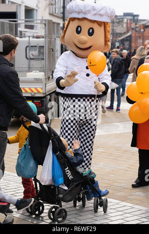 Boulangerie Mascot distribuant des ballons orange à Leeds, Briggate, West Yorkshire, Angleterre, Royaume-Uni. Banque D'Images