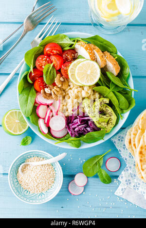 Bol avec de la viande de poulet grillé, salade de légumes frais et boulgour de radis, les tomates, l'avocat, le chou frisé et les épinards. Sain et Délicieux de l'été Banque D'Images