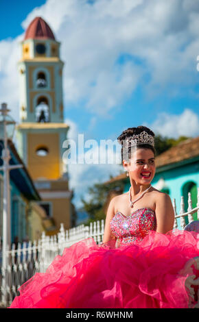 Jeune femme de couleur rose vif dans une tenue formelle à Trinidad, Cuba. Banque D'Images
