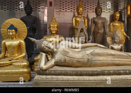 Un Bouddha couché et d'autres statues de Bouddha à l'extérieur d'un magasin d'usine pour les objets religieux dans Bamrung Muang Road, Bangkok, Thaïlande Banque D'Images