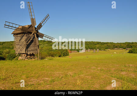 Moulin à vent est en bois debout sur une pelouse verte Banque D'Images