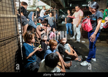 Travailleur social de la Kuya Centre pour enfants de la rue sont en contact avec les enfants sans-abri à s'inscrire sur un marché à Quezon City, Metro Manila, Philippines Banque D'Images