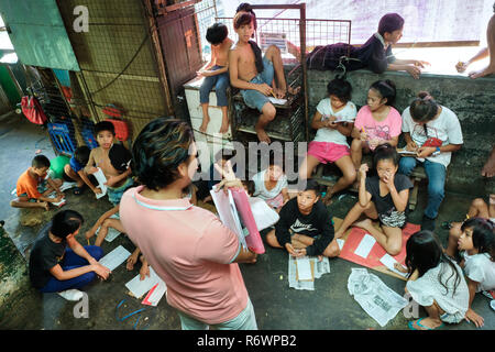 Travailleur social de la Kuya Centre pour enfants de la rue sont en contact avec les enfants sans-abri à s'inscrire sur un marché à Quezon City, Metro Manila, Philippines Banque D'Images