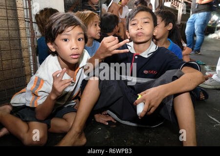 Travailleur social de la Kuya Centre pour enfants de la rue sont en contact avec les enfants sans-abri à s'inscrire sur un marché à Quezon City, Metro Manila, Philippines Banque D'Images