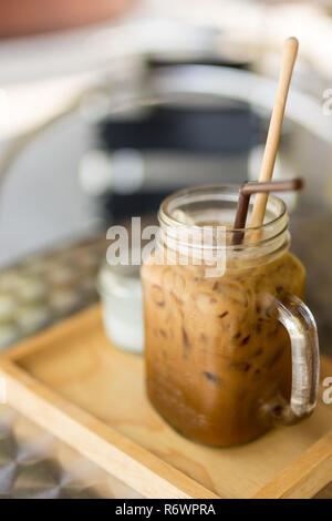 Café glacé Thai avec du lait dans un verre pot Mason sur plateau en bois et dessus de table, la profondeur de champ. Banque D'Images