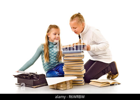 Deux petites filles avec beaucoup de livres isolé sur fond blanc Banque D'Images