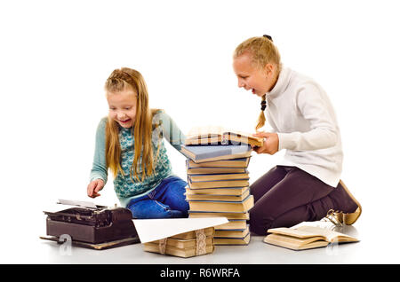 Deux petites filles avec beaucoup de livres isolé sur fond blanc Banque D'Images