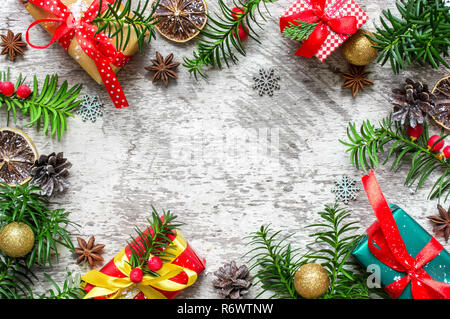 Cadre de noël faites de branches de sapin, des boîtes-cadeaux, fruits rouges. cônes et anise stars avec les oranges séchées. Composition de Noël. Télévision. Vue de dessus Banque D'Images