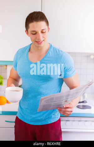 Jeune homme lit lisant le journal dans la cuisine. portrait dans le matin Banque D'Images