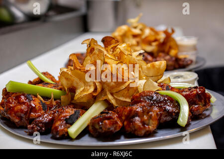 Assiette de flamme grillé les ailes de poulet frit avec les chips de pomme de terre et de céleri et sauce ranch - Prix pour l'Exemplaire Banque D'Images