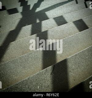 Ombre d'un auvent de fenêtre sur les escaliers dans un escalier Banque D'Images