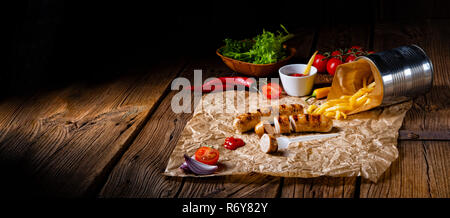 Bratwurst rustique avec pommes et ketchup fort Banque D'Images